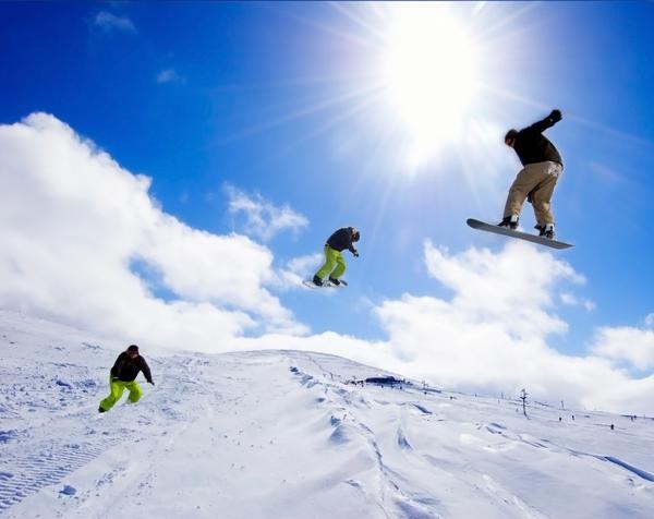 Snowboarders performing tricks in mid air
