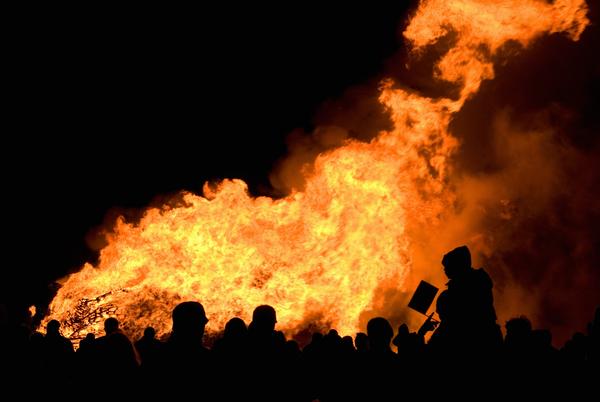 Crowd in silhouette enjoying a large bonfire