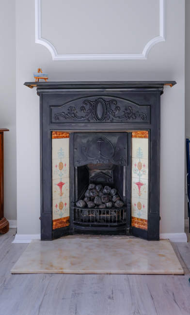 Traditional cast iron fireplace with tiles and marble hearth.