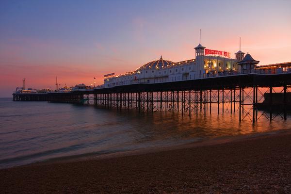 © Shutterstock / Scotshot Brighton Pier at night with name showing up in red lights