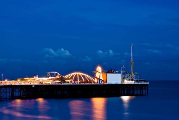 © Shutterstock / Francesco Carucci Brighton Pier at night with the funfair illuminated by bright lights