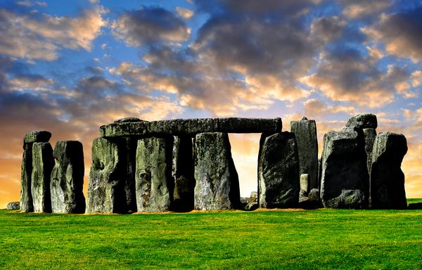 Ancient Stonehenge with dramatic clouds in sky above and behind
