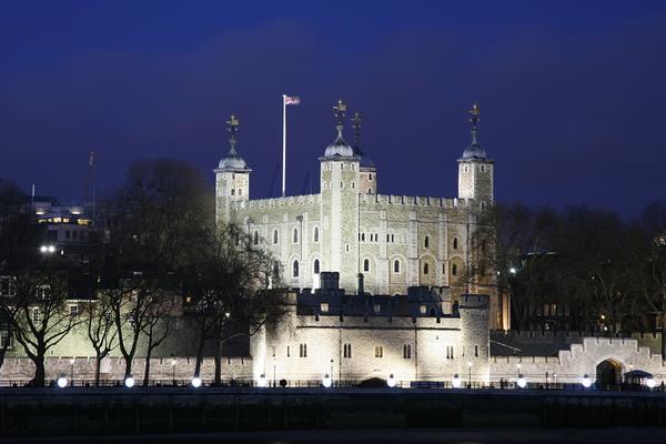 The Tower of London illuminated at night, viewed from the Thames