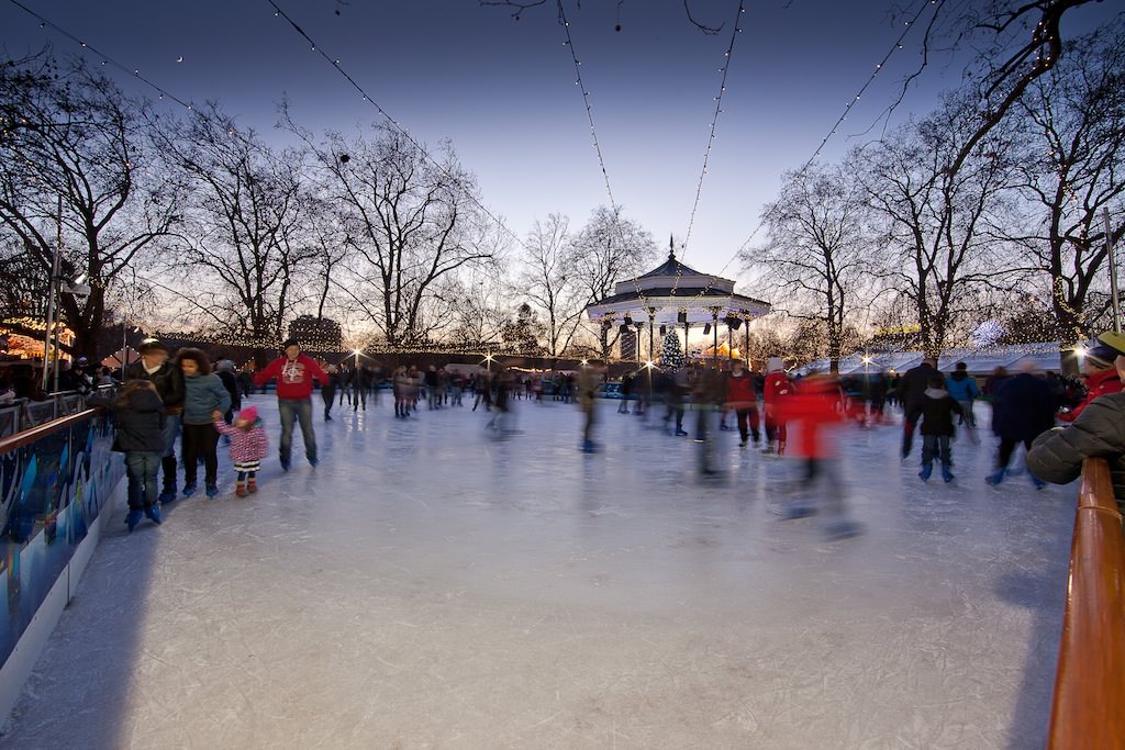Hyde Park Christmas Ice Rink at sunset, with some of the skaters spinning in the foreground