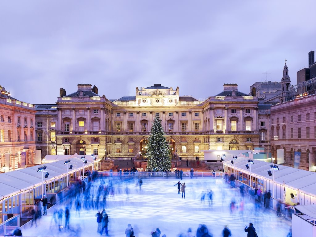 Christmas Ice Rink set up in the courtyard of Somerset House with large lit Christmas tree