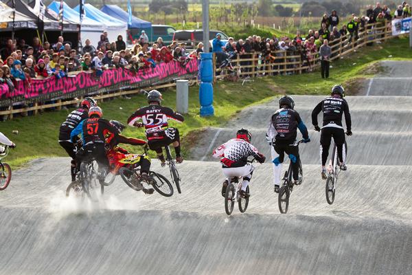 BMX riders wearing brightly coloured shirts competing in the BMX championships at the Kent Cyclopark, Gravesend